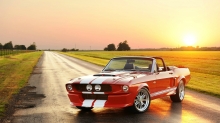 Последние минуты солнце смотрит на красный Ford Mustang кабриолет